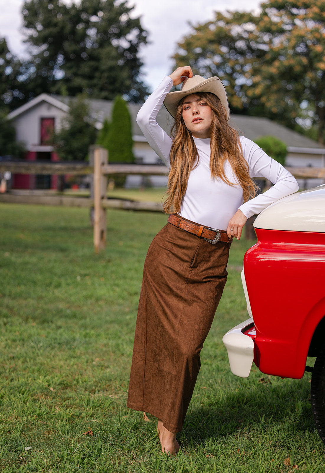 Woman in cowboy hat and brown suede maxi skirt 
