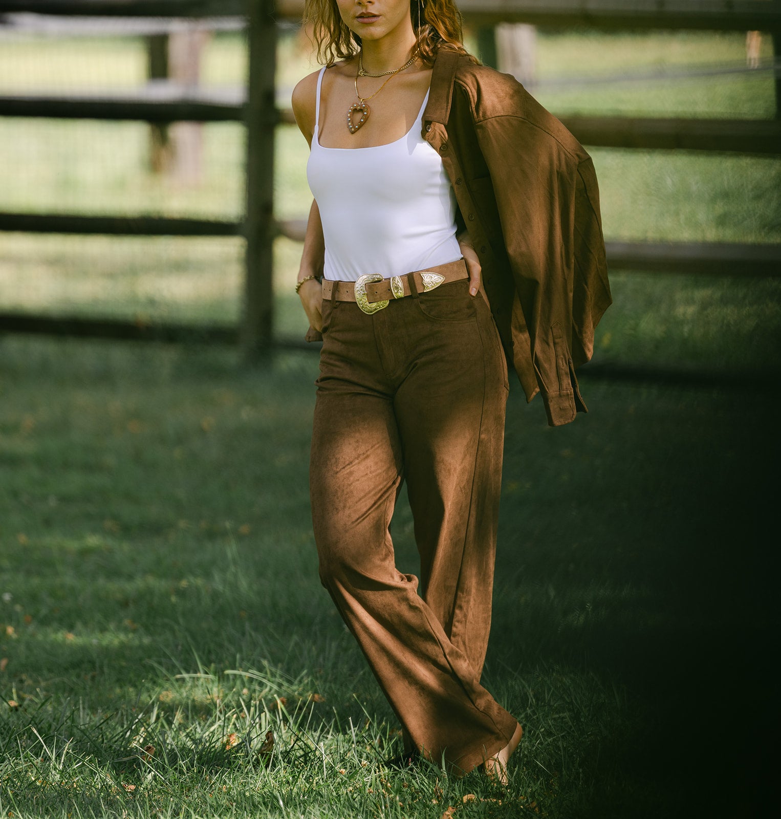 model wearing brown suede pants with a white tank and matching brown suede button down shirt