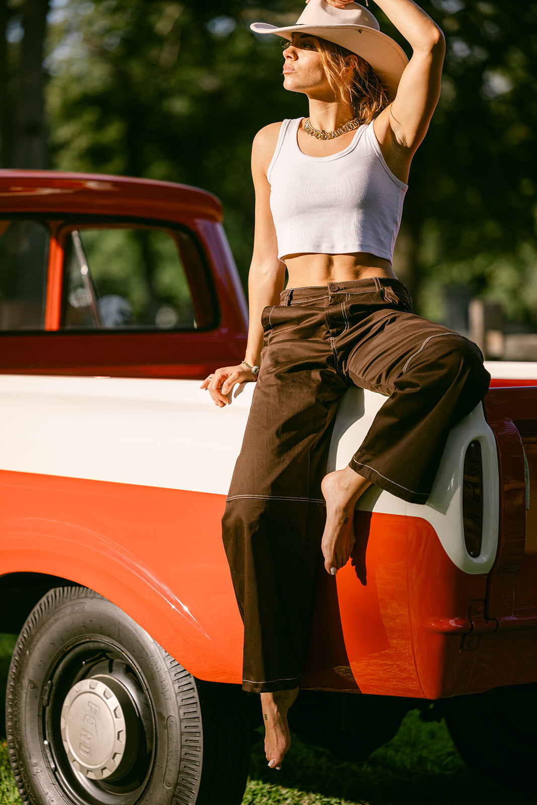 woman wearing brown stitching wide leg pants with a white tank