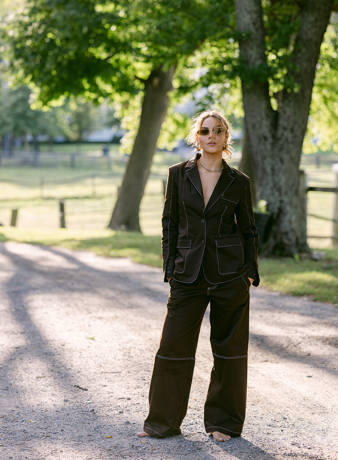 women wearing a brown stitching blazer with brown stitching wide leg pants suit